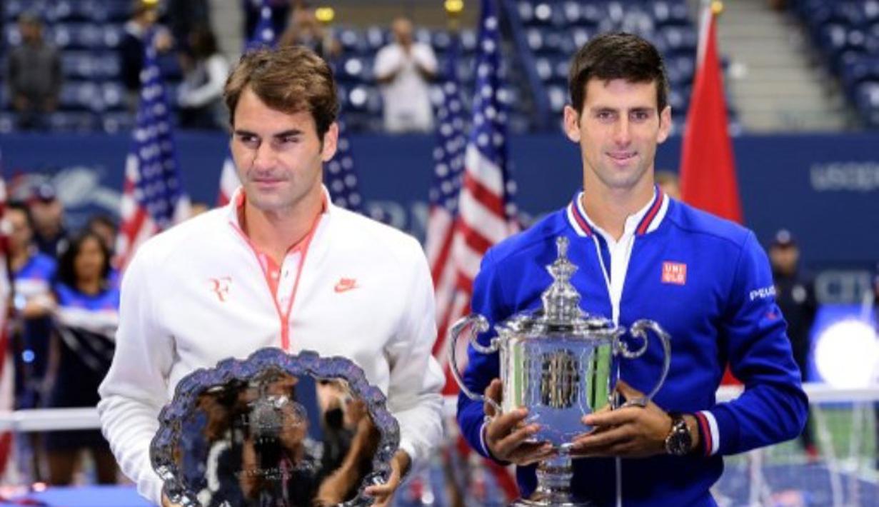 Roger Federer dan Novak Djokovic berpose dengan trofi juara AS Terbuka di lapangan Stadion Arthur Ashe, Senin (14/8/2015) pagi WIB. (AFP Photo/Jewel Samad)