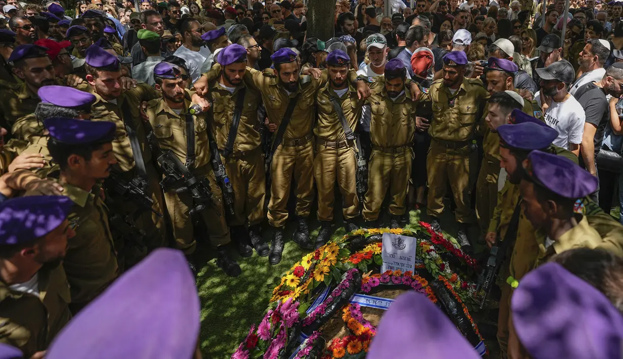 Tentara Israel berpelukan di dekat makam Staf Sersan. Shilo Yosef Amir saat pemakamannya di pemakaman Mount Herzl di Yerusalem, Jumat, 7 Juli 2023. (AP Photo/Ohad Zwigenberg)