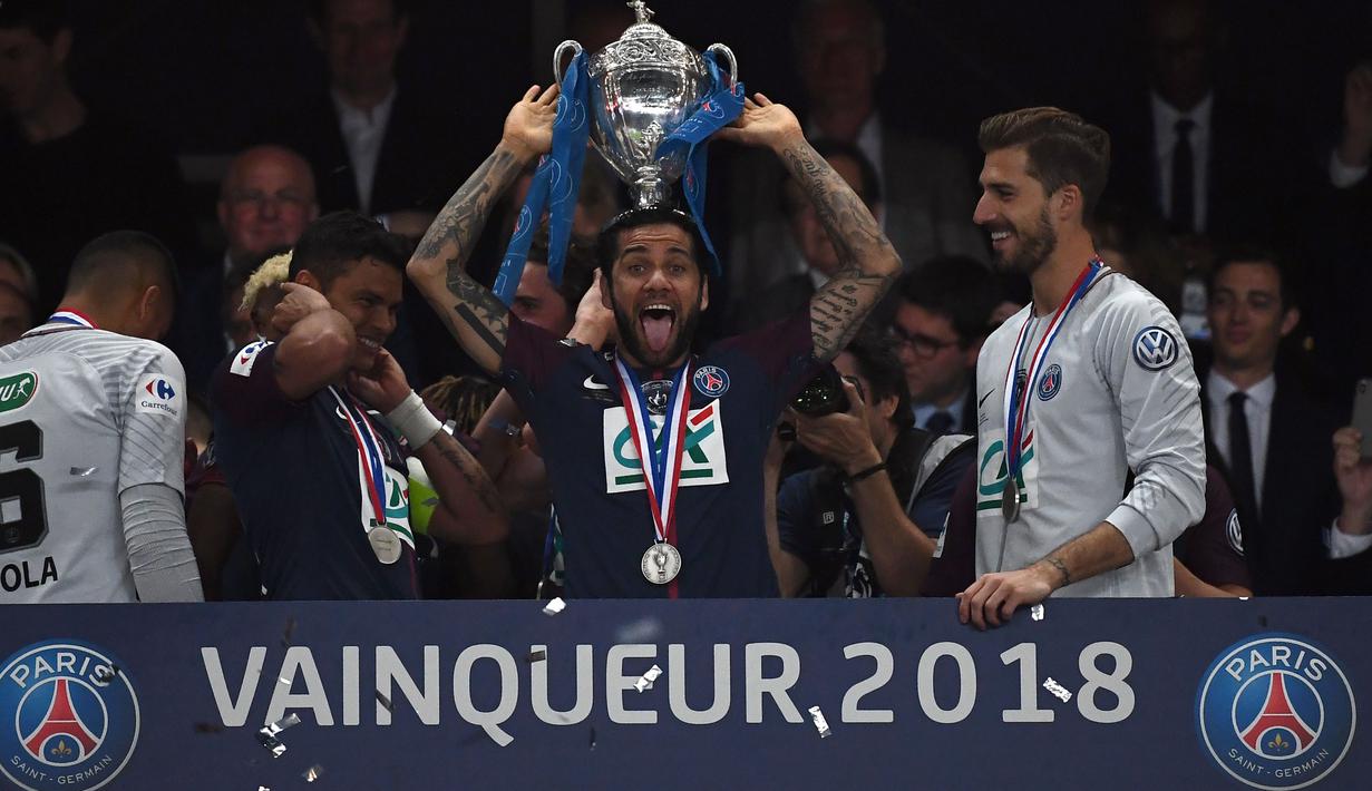 Daniel Alves mengangkat trofi Piala Prancis usai timnya mengalahkan Les Herbiers di Stade de France, Saint-Denis, (8/5/2018). Menurut sumber terkait diagnosa awal Alves mengalami cedera ligamen anterior. (AFP/Franck FIfe)