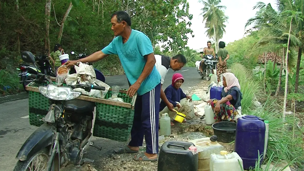 Warga Mengambol Aor dari Bocoran Pipa PDAM