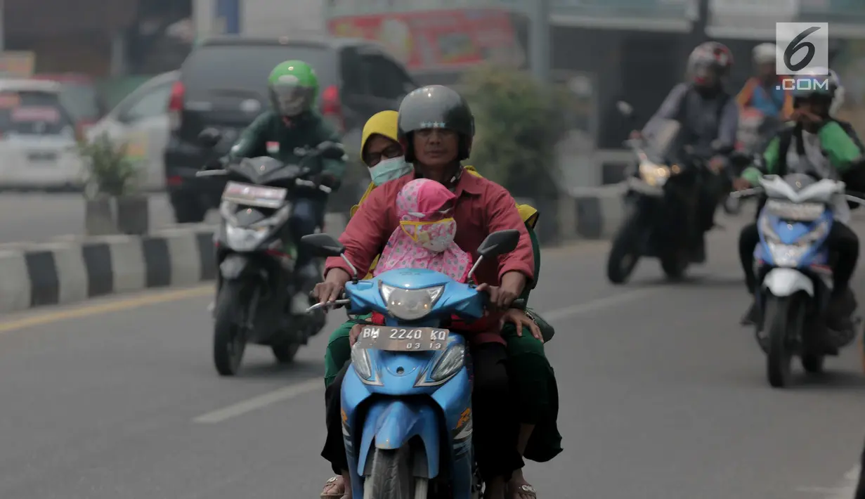 Pengendara motor menembus kabut asap pekat yang menyelimuti Kota Pekanbaru, Riau, Selasa (10/9/2019). Kabut asap akibat kebakaran hutan dan lahan (karhutla) tersebut menurunkan jarak pandang dan kualitas udara turun ke status tidak sehat. (Liputan6.com/Faizal Fanani)