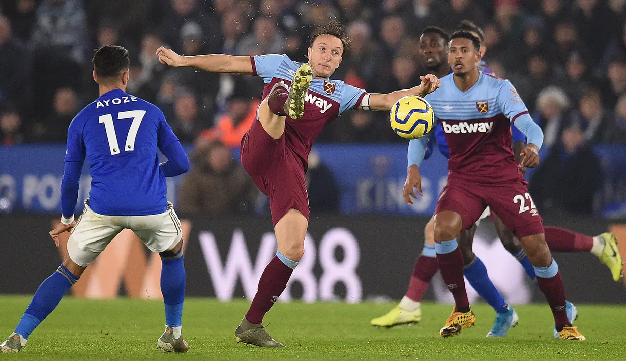 Striker Leicester City, Ayoze Perez berebut bola dengan gelandang West Ham United, Mark Noble (tengah) pada pekan 24 Liga Inggris 2019-2020 di Stadion King Power, Rabu (22/1/2020). Menjamu West Ham , Leicester City berhasil menang meyakinkan dengan skor akhir 4-1. (Oli SCARFF / AFP)