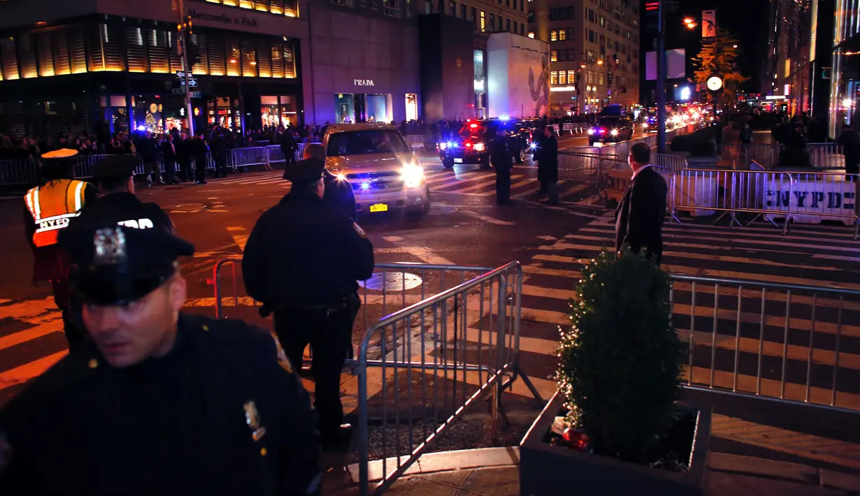 Petugas melakukan penjagaan di luar Trump Tower di 5th Avenue, New York, Kamis (10/11). Seiring munculnya gelombang unjuk rasa anti Trump, markas Presiden terpilih AS itu dijaga ketat sejumlah personel Departemen Kepolisian New York. (KENA BETANCUR/AFP)