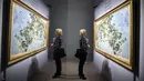 Refleksi dari cermin yang menggambarkan seorang wanita melihat lukisan Claude Monet 'The Roses' saat pameran 'Monet. Capolavori dal Musee Marmottan' di Roma, Italia (18/10). (Angelo Carconi / ANSA via AP)