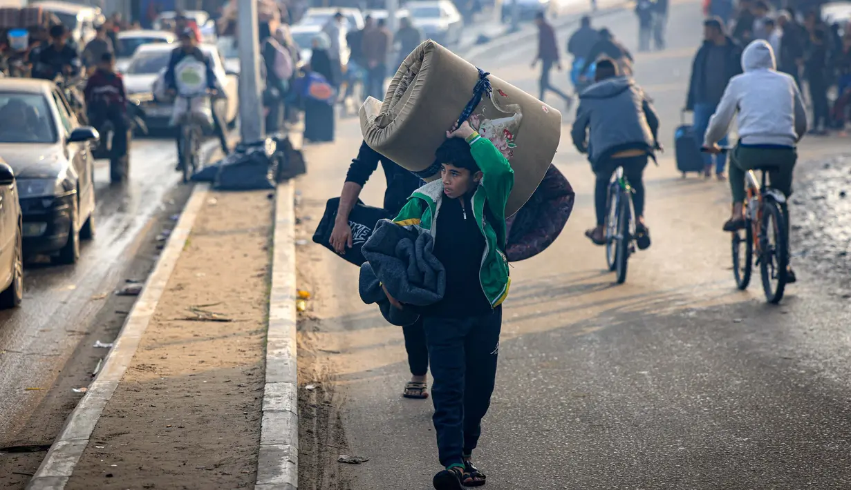 Warga Palestina membawa sejumlah barang saat mengungsi ke daerah yang lebih aman menyusul dimulainya kembali serangan Israel ke Rafah di Jalur Gaza selatan pada 1 Desember 2023. (MAHMUD HAMS/AFP)