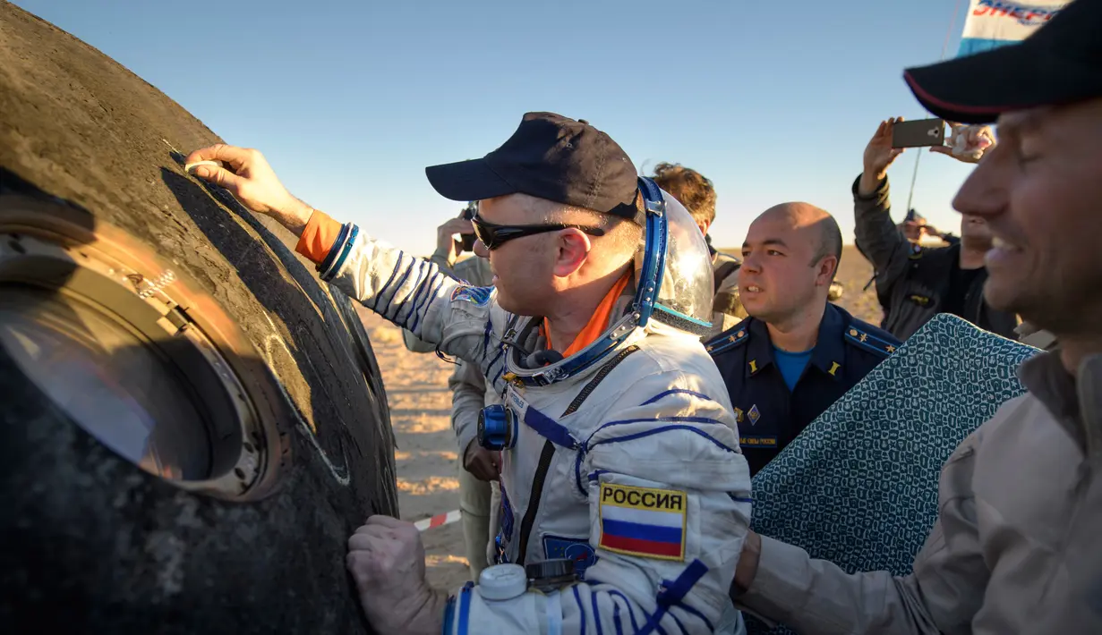 Kosmonot Rusia Oleg Artemyev menandatangani bagian luar kapsul ruang angkasa Soyuz MS-08 sesaat setelah mendarat di luar Kota Dzhezkazgan, Kazakhstan, Kamis (4/10). (Bill Ingalls / NASA via AP)