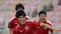 Bek Jepang, Takehiro Tomiyasu membawa bola selama sesi latihan di Stadion King Abdullah Sport City di Jeddah (6/10/2021). Jepang akan bertanding melawan Arab Saudi pada grup B Kualifikasi Dunia Qatar 2022 di Stadion King Abdullah Sports City. (AFP Photo)