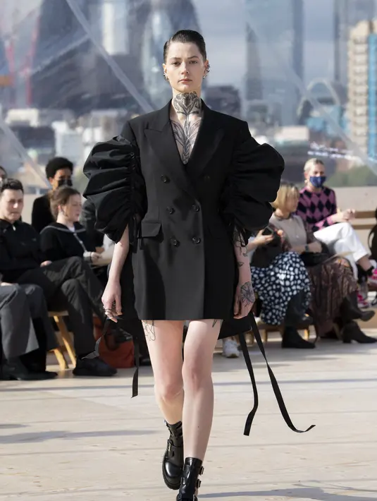 Sarah Burton, Creative Director Alexander McQueen berusaha menginterpretasikan London sebagai tempat hidup dan bekerjanya dan perempuan dari kacamata brand ini sendiri, lewat koleksi SS 2022. Coat bermodel double-breasted dari wol hitam dengan lengan poly faille. Foto: Document/Alexander McQueen.