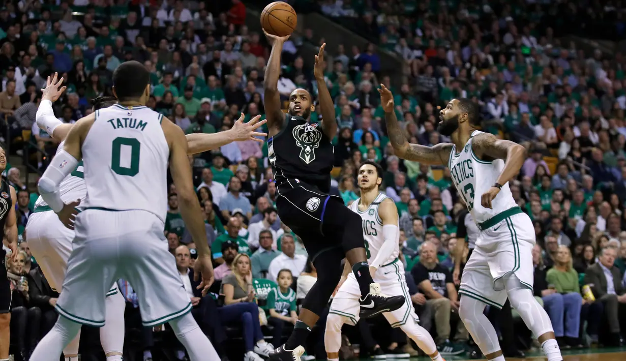 Aksi pemain Milwaukee Bucks, Khris Middleton (tengah) melakukan tembakan melewati adangan pemain Boston Celtics pada laga playoffs NBA basketball di TD Garden, Boston, (24/4/2018). Celtics menang  92-87. (AP/Charles Krupa)