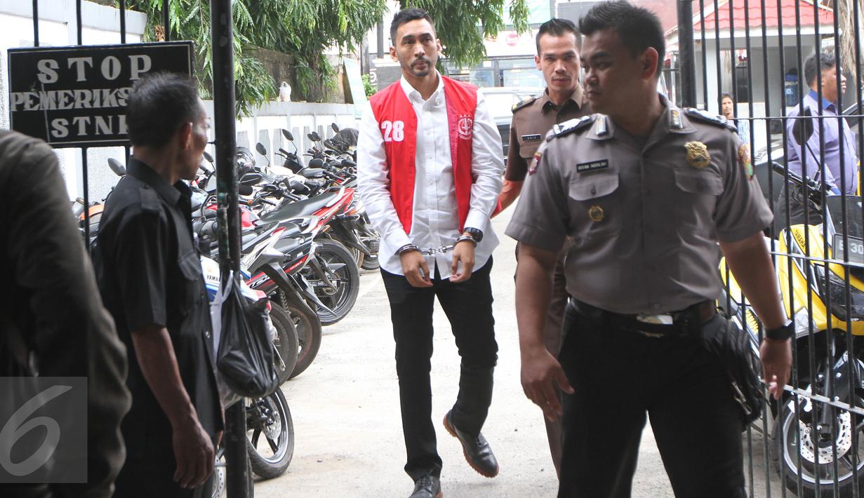 Aktor Restu Sinaga dengan tangan diborgol dan pengawalan petugas tiba di Pengadilan Negeri Jakarta Selatan, Kamis (13/10). Restu Sinaga akan menjalani sidang perdana atas kasus kepemilikan narkoba pada Juni lalu. (Liputan6.com/Herman Zakharia)
