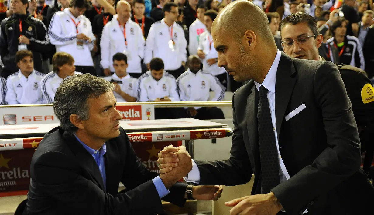 Pelatih asal Portugal Jose Mourinho (kiri) berjabat tangan dengan pelatih Barcelona Josep Guardiola sebelum pertandingan final Piala Spanyol Real Madrid melawan Barcelona di Stadion Mestalla di Valencia pada 20 April 2011. (AFP PHOTO/Lluis GENE)