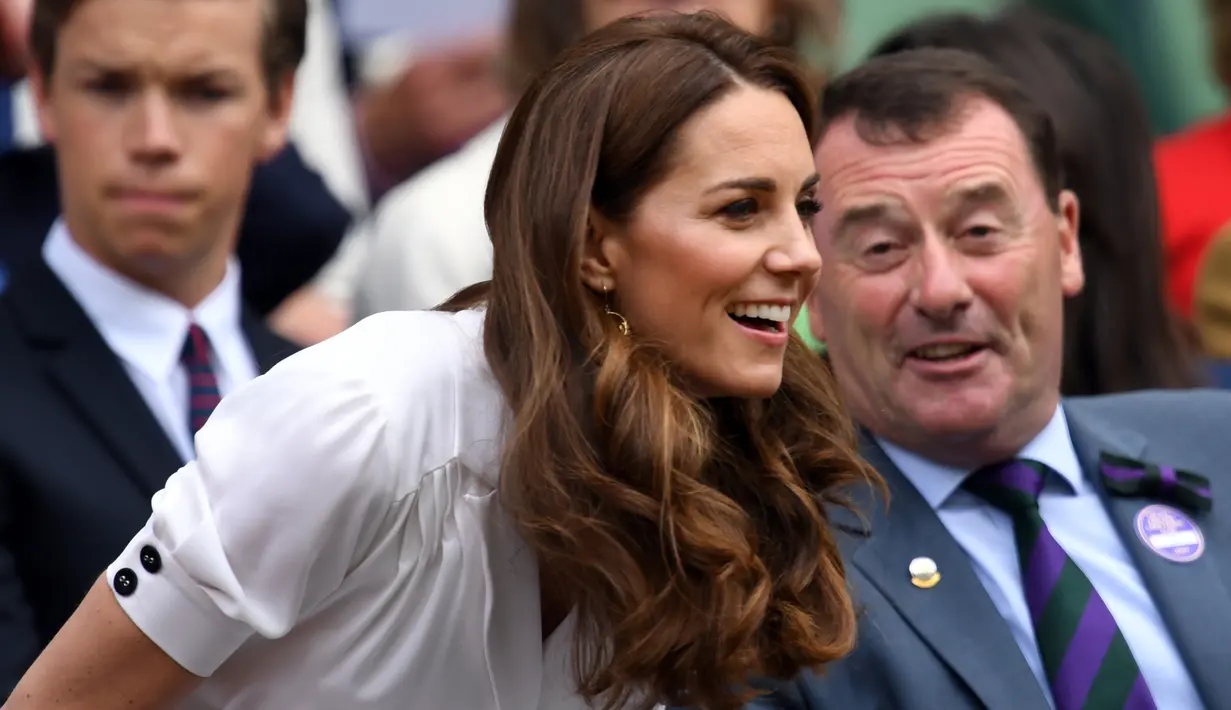 Kate Middleton bersiap menyaksikan petenis Jerman, Tatjana Maria melawan Angelique Kerber pada turnamen tenis Wimbledon 2019, London (2/7/2019). Kate Middleton bergaun gaun putih dari Suzannah dan tas tangan Alexander McQueen dan kacamata hitam Ray-Ban. (AFP Photo/Glyn Kirk)