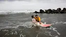 Senji saat mengajak Saori bermain di pantai, Jepang (April 2017). Lebih dari 7 tahun Senji hidup bersama Saori padahal, Senji telah memiliki istri dan dua orang anak. (AFP Photo/ Behrouz MEHRI)