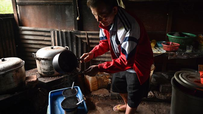 Seorang pria membuat kopi Kawa Daun di sebuah kafe tradisional, Tabek, Sumbar (29/11). Keunikan kopi di daerah ini adalah minuman yang mengekstrak rasa dari daun tanaman daripada kacangnya. (AFP Photo/Adek Berry)