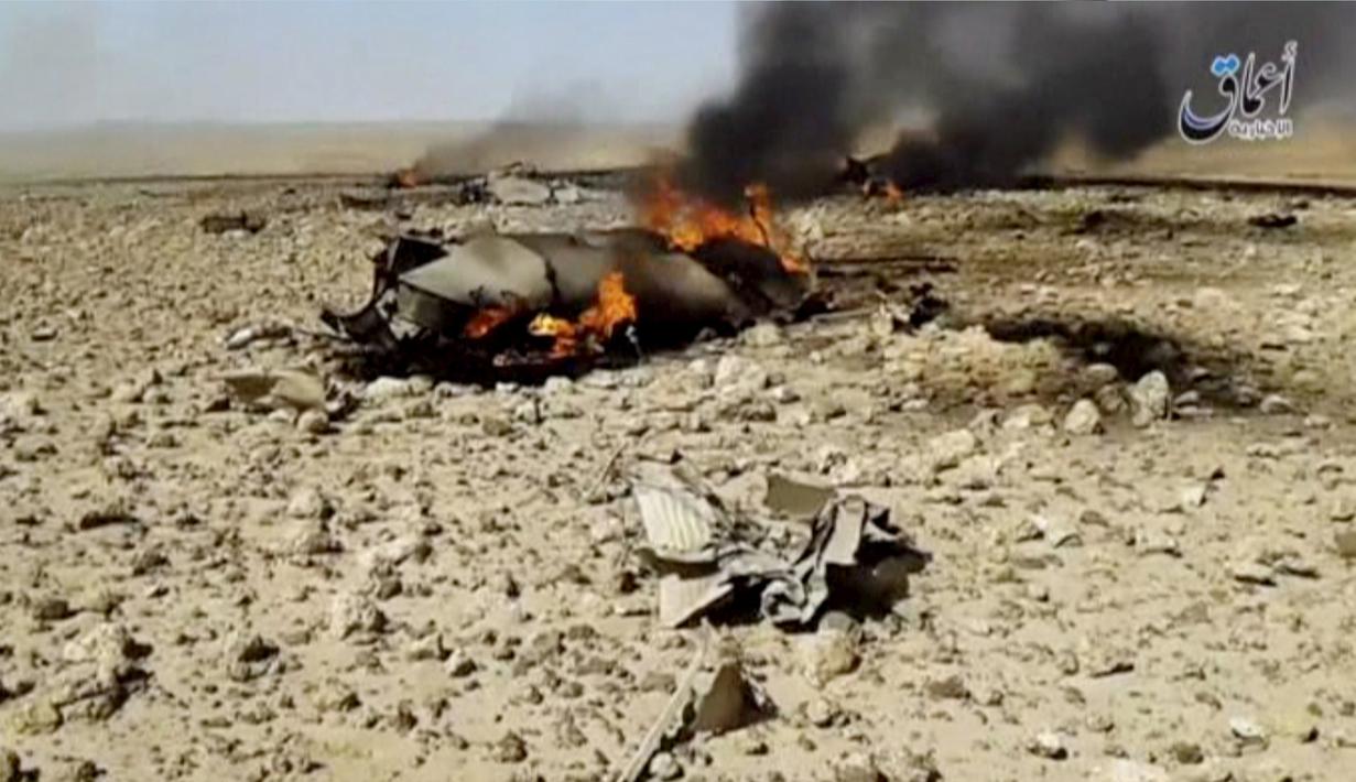 Tampak bangkai pesawat yang jatuh dan terbakar di sebelah tenggara Damaskus, Jumat, (22/4). Kelompok Islamic State atau ISIS mengklaim menembak jatuh pesawat jet tempur Suriah tersebut. (Reuters)