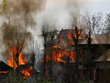 Sejumlah bangunan tempat tinggal terbakar akibat pertempuran senjata antara kelompok militan dan pasukan keamanan India di Shopian, Srinagar (4/1). Situasi wilayah ini kian memanas dan sering terjadi bentrokan. (AP Photo / Mukhtar Khan)