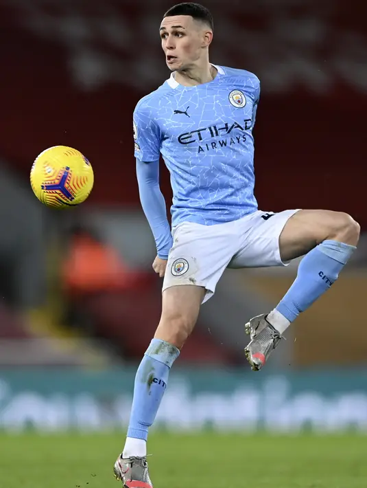 Gelandang Manchester City, Phil Foden mengontrol bola saat bertanding melawan Liverpool pada pertandingan lanjutan Liga Inggris di Stadion Anfield, Inggris, Senin (8/2/2021).  City menang telak atas Liverpool 4-1. (Laurence Griffiths/Pool via AP)