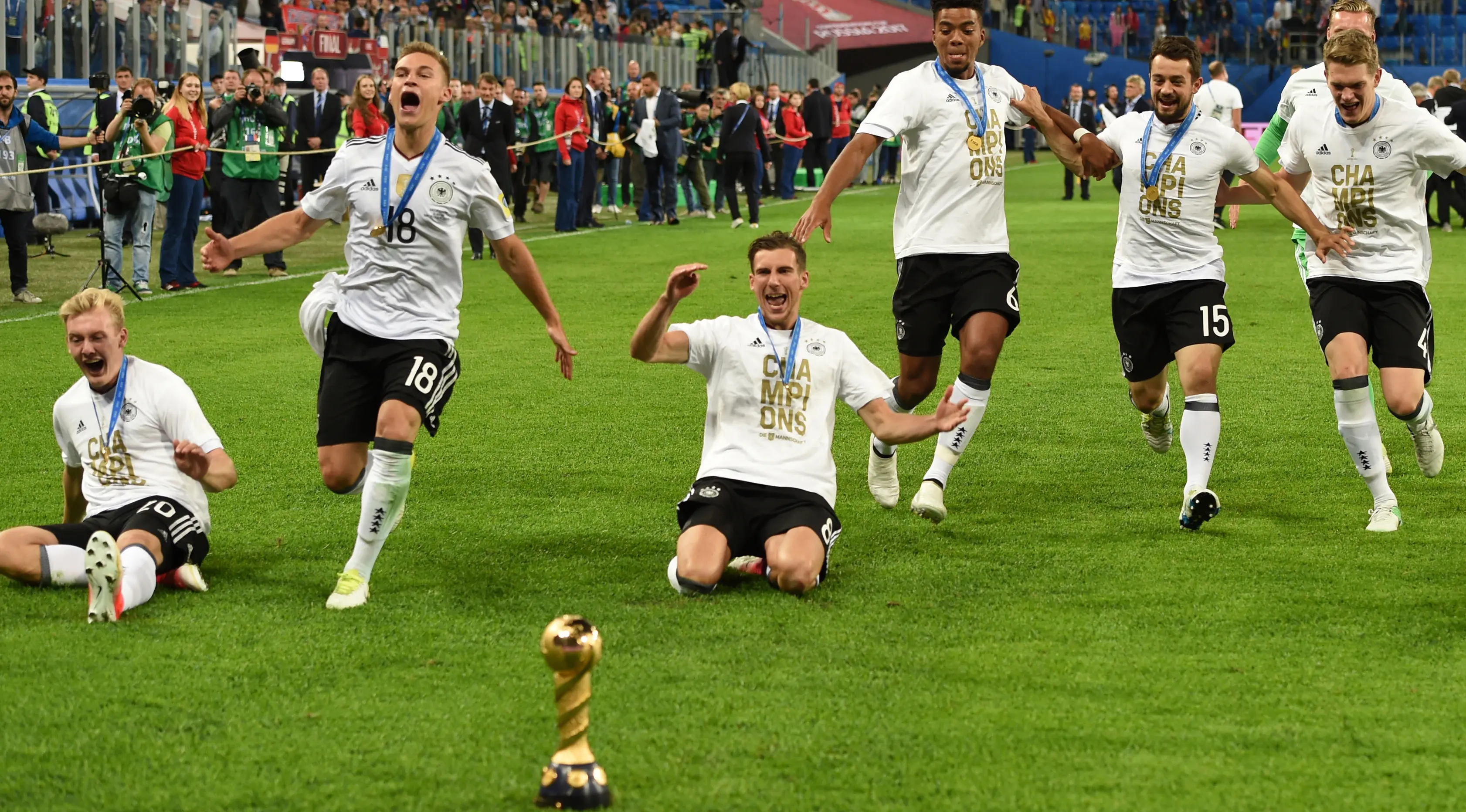 Pemain Jerman berlari menuju piala saat merayakan kemenangannya dalam final Piala Konfederasi 2017 di Stadion Saint Petersburg, Rusia (2/7). (AFP Photo/Patrik Stollarz)