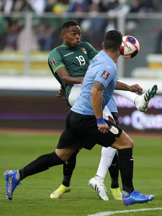 Pemain Uruguay Luis Suarez (kanan) melihat pemain Bolivia Marc Enoumba mengontrol bola pada pertandingan kualifikasi Piala Dunia 2022 di Stadion Hernando Siles, La Paz, Bolivia, 16 November 2021. Bolivia menang 3-0. (AP Photo/Juan Karita)