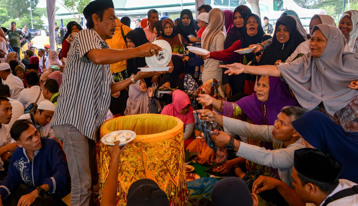Orang-orang menunggu untuk menerima porsi makan siang pada perayaan maulid akbar Nabi Muhammad SAW di Banda Aceh, Aceh, Kamis (6/2/2020). Acara itu menyediakan 808 hidangan dari 90 desa dan instansi pemerintah dengan mengundang 25.000 tamu dari berbagai daerah. (Photo by Chaideer MAHYUDDIN / AFP)