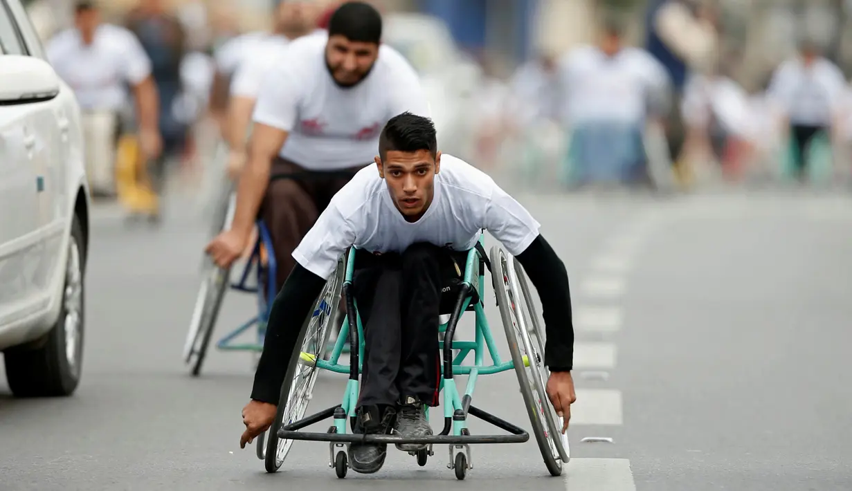 Sejumlah warga difable Palestina mengayuh roda saat bersaing dalam perlombaan kursi roda yang diselenggarakan oleh Masyarakat Amal Assalama di Kota Gaza, (29/11). (REUTERS/Suhaib Salem)