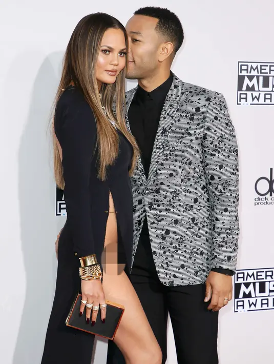 Kemesraan pasangan John Legend dan Chrissy Teigan saat berpose di karpet merah American Music Awards (AMA) 2016 di Los Angeles, Minggu (20/11). Chrissy mengenakan gaun berbelahan sangat tinggi yang hampir mengekspos organ intimnya (REUTERS/Danny Moloshok)