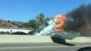 Kendaraan melintas di dekat pesawat antik Amerika Utara AT-6 yang terbakar di US 101 di Agoura Hills, California (23/10). Kecelakaan menyebabkan kemacetan panjang sekitar 50 km di sebelah barat pusat kota Los Angeles. (AFP Photo/Cynthia Alvarez)