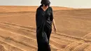 Di tengah padang pasir, Donna tampil anggun mengenakan kaftan hitam dan sorban. [@dagnesia]