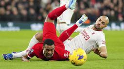 Pemain Liverpool, Ryan Gravenberch (kiri) tersungkur setelah berebut bola dengan pemain Manchester United, Sofyan Amrabat pada laga lanjutan Liga Inggris 2023/2024 di Anfield, Liverpool, Inggris, Rabu (18/12/2023) dini hari WIB. (AP Photo/Jon Super)