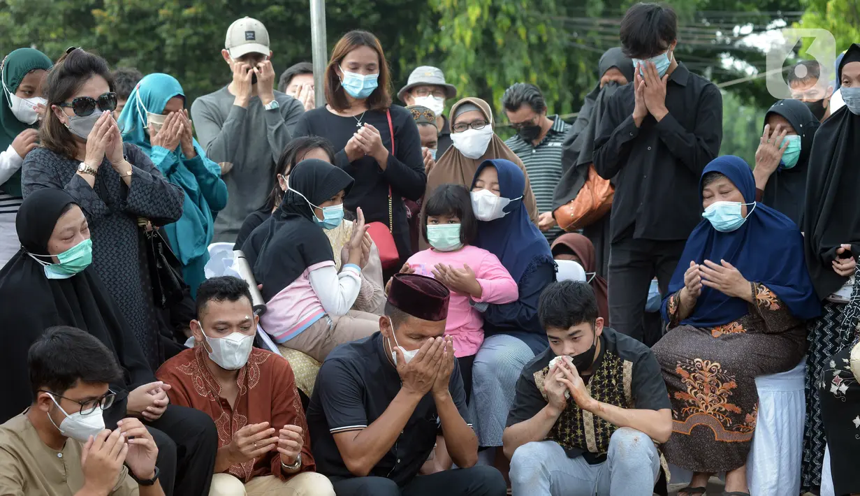 Keluarga dan kerabat memanjatkan doa saat pemakaman mantan pebuku tangkis Indonesia Markis Kido di TPU Kebon Nanas, Jakarta, Selasa (15/6/2021). Markis Kido meniggal dunia diduga akibat serangan jantung. (merdeka.com/Imam Buhori)