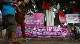 Warga melintas di dekat spanduk yang bertuliskan dukungan untuk Jokowi di sekitar Tugu Proklamasi, Jakarta, Kamis (21/5/2015). Spanduk tersebut dipasang dalam rangka memperingati 17 tahun peringatan reformasi. (Liputan6.com/Faizal Fanani)