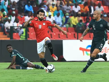 Penyerang Mesir, Mohamed Salah (kiri) berebut bola dengan bek Nigeria, William Troost-Ekong pada pertandingan Grup D Piala Afrika (CAN) 2021 di Stade Roumde Adjia di Garoua (12/1/2022). Nigeria menang tipis atas Mesir tipis 1-0 lewat gol Kelechi Iheanacho di menit ke-30. (AFP/Daniel Beloumou Olomo)