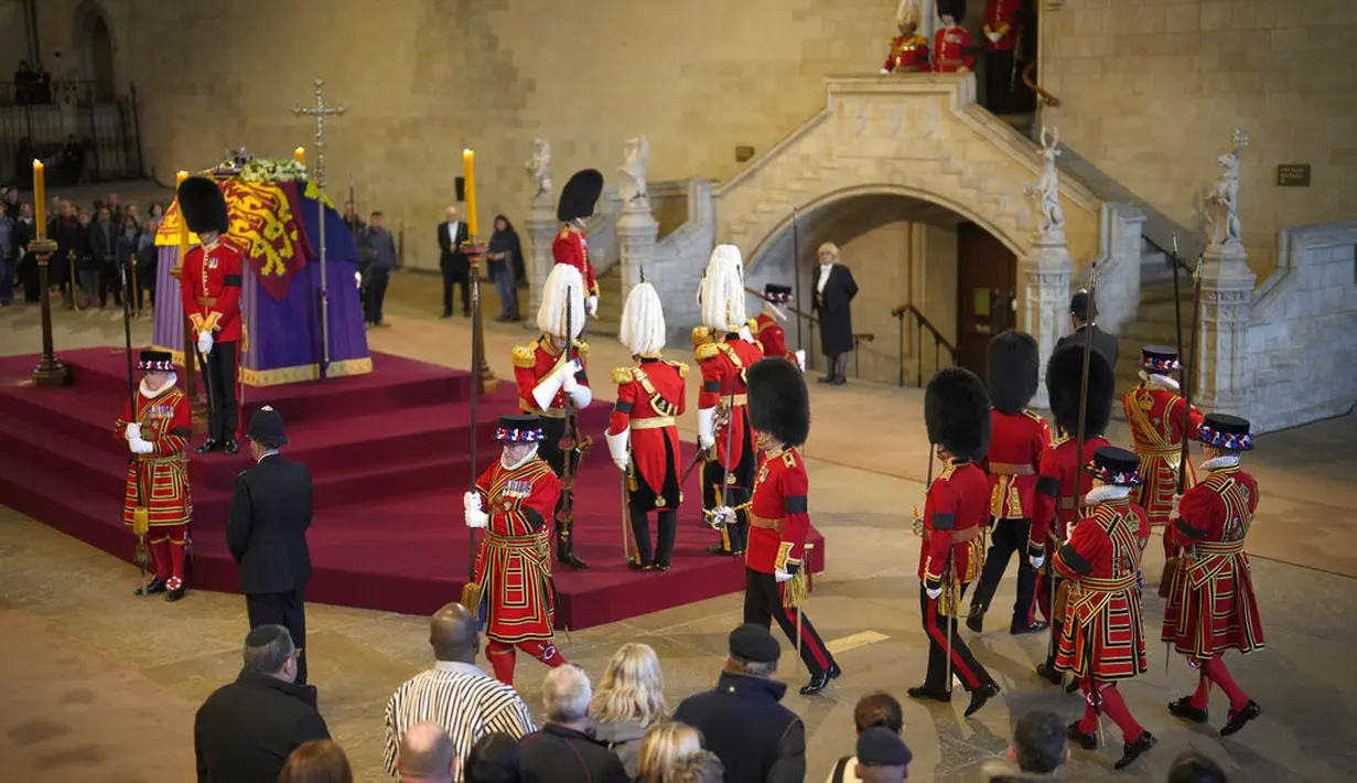 The King's Body Guard yang terdiri dari Gentlemen at Arms, Yeomen of the Guard dan Scots Guards menjaga lokasi persemayaman Ratu Elizabeth II. (AP Photo/Vadim Ghirda, pool)