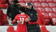Manajer Liverpool, Jurgen Klopp, memeluk pemainnya, Mohamed Salah, setelah The Reds kalah 0-2 dari Everton dalam laga derbi Merseyside di Anfield pada pekan ke-25 Premier League, Minggu (21/2/2021). (PAUL ELLIS / POOL / AFP)