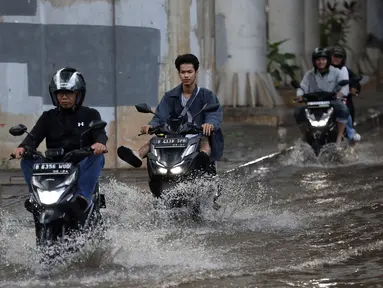 Pengendara melintasi genangan banjir di Jalan Ciledug Raya, kawasan Pasar Cipulir, Jakarta Selatan, Jumat (28/4/2023). (Liputan6.com/Johan Tallo)
