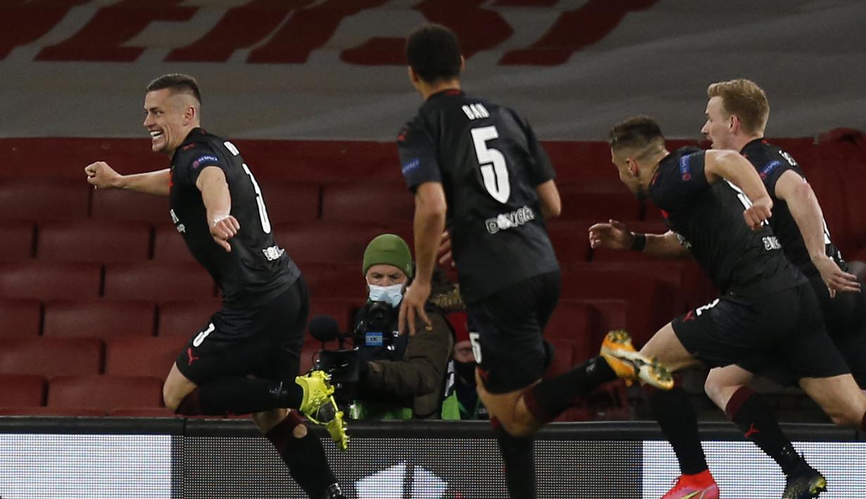 Para pemain Slavia Praha merayakan gol penyeimbang 1-1 ke gawang Arsenal yang dicetak bek Tomas Holes (kiri) dalam laga leg pertama perempatfinal Liga Europa 2020/2021 di Emirates Stadium, London, Kamis (8/4/2021). Slavia Praha bermain imbang 1-1 dengan Arsenal. (AFP/Ian Kington)
