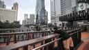 Warga berfoto saat ngabuburit di JPO Pinisi Pinisi Karet-Sudirman, Jakarta Pusat, Senin (4/4/2022). JPO Pinisi kini menjadi destinasi baru warga Jakarta untuk menunggu waktu berbuka puasa atau ngabuburit sambil menikmati suasana perkotaan. (merdeka.com/Iqbal S. Nugroho)