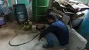 Pengurus RW 01 menyalakan tungku untuk memulai proses pengolahan sampah plastik menjadi bahan bakar alternatif atau petasol di Jakarta, Senin (19/10/2026). Bahan bakar yang dihasilkan dimanfaatkan untuk menunjang kebutuhan operasional pos RW, termasuk kendaraan bermotor. (KLY/Budy Santoso)
