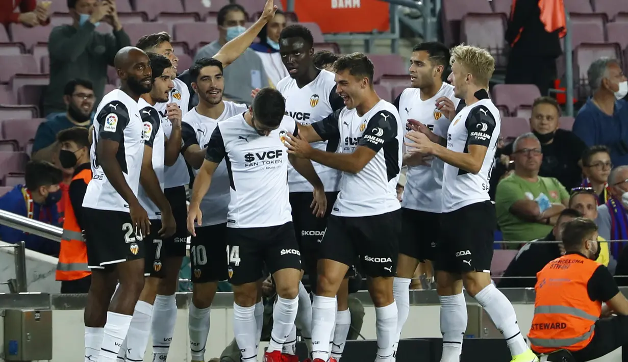 Para pemain Valencia berselebrasi setelah Jose Gaya mencetak gol ke gawang Barcelona pada lanjutan La Liga Spanyol di stadion Camp Nou di Barcelona, Spanyol, Senin (18/10/2021). Barcelona menang atas Valencia dengan skor 3-1. (AP Photo/Joan Monfort)