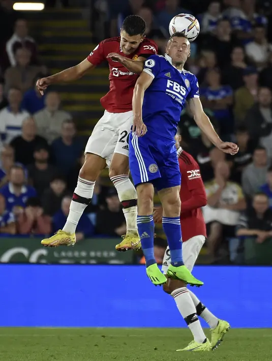 Bek Manchester United (MU) Diogo Dalot dan penyerang Leicester City Jamie Vardy melompat untuk berebut bola dalam lanjutan Liga Inggris 2022/2023 pekan ke-5 di King Power Stadium, Jumat (2/9/2022) dini hari WIB. MU menang 1-0 atas Leicester City lewat gol yang dilesakkan Jadon Sancho.  (AP Photo/Rui Vieira)