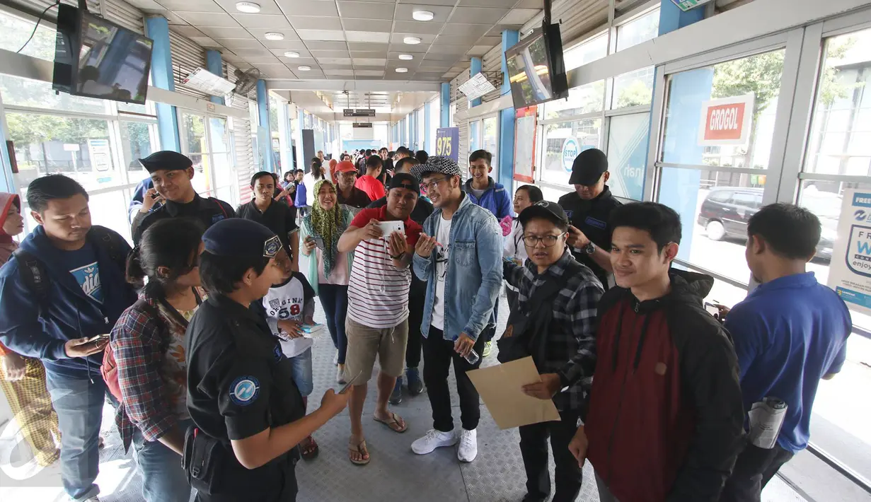 Penumpang foto bersama dengan vokalis grup musik Nidji, Giring di Halte Transjakarta Sarinah, Thamrin, Jakarta Pusat, Senin (27/3). Acara tersebut diadakan dalam rangka memperingati ulang tahun ke-3 PT Transjakarta. (Liputan6.com/Immanuel Antonius)
