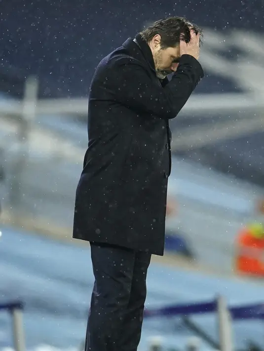 Pelatih PSG, Mauricio Pochettino memegang kepalanya saat menyaksikann pemainnya bertanding melawan Manchester City pada leg kedua semifinal Liga Champions di stadion Etihad, Rabu (5/5/2021). City menang atas PSG 2-0. (AP Photo/Dave Thompson)
