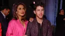 <p>Priyanka Chopra (kiri) dan Nick Jonas menghadiri koleksi siap pakai Valentino Fall/Winter 2023-2024 yang dipresentasikan di Paris Fashion Week, Paris, Prancis, 5 Maret 2023. Jonas mengenakan setelan kotak-kotak abu-abu di atas atasan hitam dan sepatu bot hitam. (Vianney Le Caer/Invision/AP)</p>