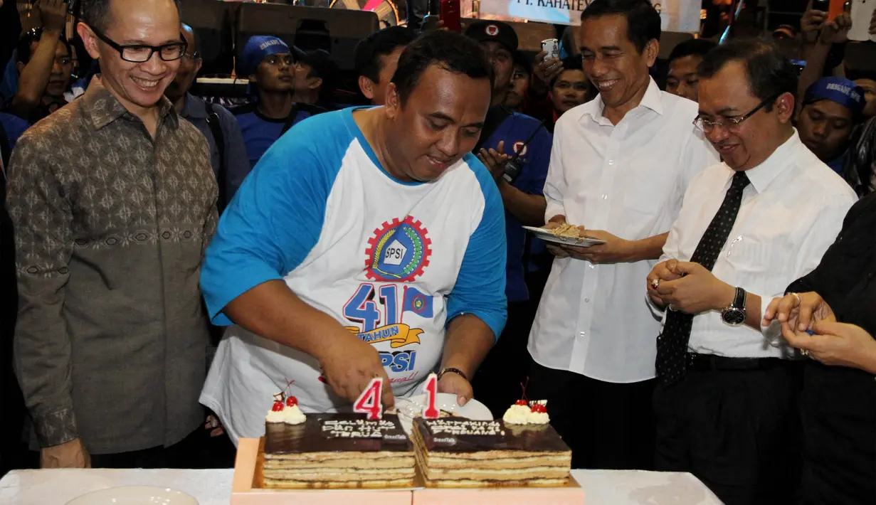 Jokowi tersenyum mendapat potongan kue ulang tahun. Priyo sedang menunggu giliran (Liputan6.com/Johan Tallo).