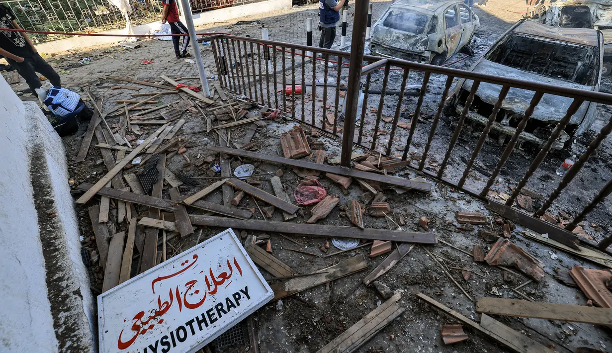 <p>Orang-orang mencari di antara puing-puing di luar lokasi rumah sakit Ahli Arab di pusat kota Gaza pada tanggal 18 Oktober 2023. (MAHMUD HAMS/AFP)</p>