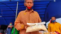 Sutoyo (52), salah satu petani padi di Desa Nusakarta Jalur 27 Kecamatan Air Sugihan Kabupaten OKI Sumsel yang menunjukkan beras hasil panennya yang mengalami penurunan harga jual (Liputan6.com / Nefri Inge)