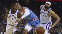 Ekspresi pemain Sacramento Kings, Skal Labissiere (tengah) saat berebut bola dengan dua pemain Warriors  pada laga NBA basketball game di Golden 1 Center, Oakland, California, (16/3/2018). King menang 98-93. (AP/Ben Margot)