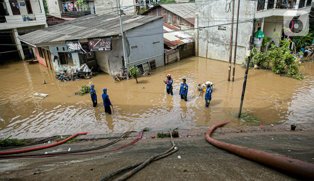 Petugas pemadan kebakaran menyedot air banjir di kawasan Cipinang Melayu, Jakarta, Minggu (21/2/2021). Suku Dinas Pemadam Kebakaran Jakarta Timur mengerahkan 20 mobil pompa untuk menyedot air yang membanjiri RW 04 Kelurahan Cipinang Melayu untuk mengurangi debit air. (Liputan6.com/Faizal Fanani)