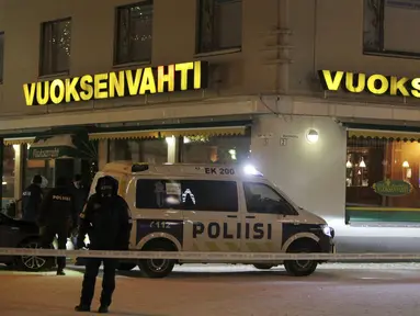Petugas kepolisian berjaga di lokasi penembakan yang terjadi di luar restoran di Imatra, kota kecil di dekat perbatasan Finlandia dan Rusia, Minggu (4/12). Tiga orang wanita ditembak mati seorang pria bersenjata. (Lauri Heino/Lehtikuva via REUTERS)