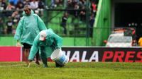 Pekerja Stadion Gajayana, Malang, membuat garis lapangan dengan cara manual. (Bola.com/Iwan Setiawan)